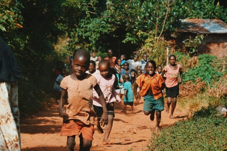 african kids running on a mud road joyfully