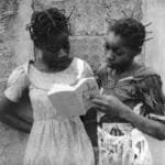 two african girls reading a book