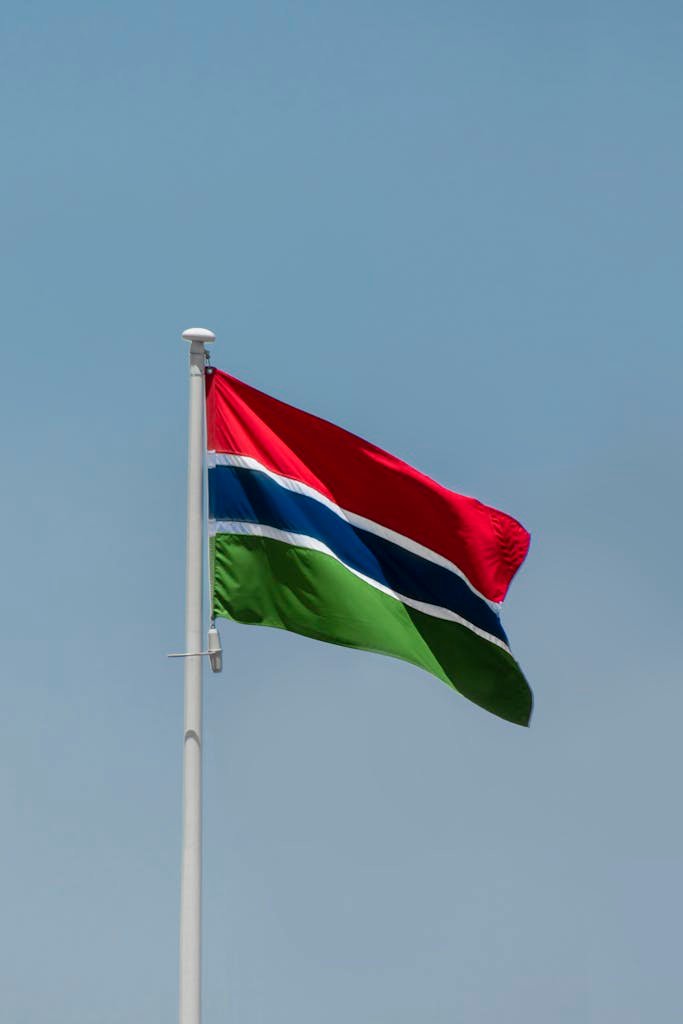 The Gambian flag in the blue sky waving on a clear, sunny day in Banjul the capital.