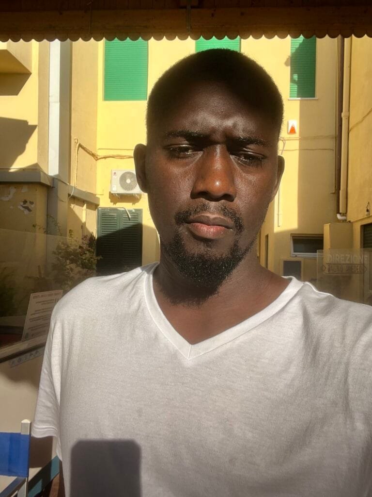 lamin ceesay at viareggio sea side on white shirt and buildings behimd me