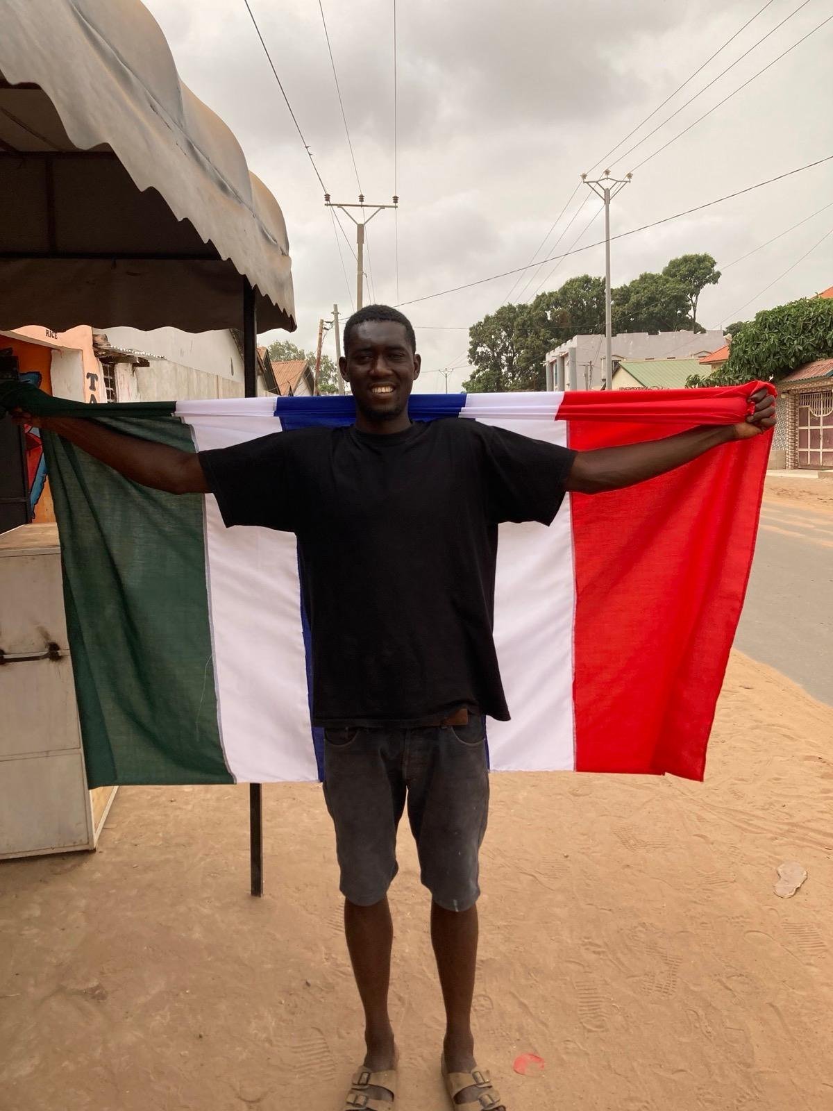 Holding the flag of the Gambia